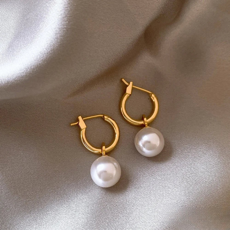 Eleganta örhängen med gyllene pärlor